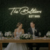 Custom wedding neon sign with last names, illuminated in vibrant colors, designed for wedding decor by Light Your Way.