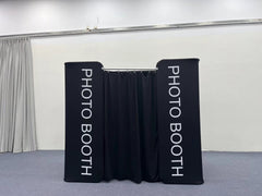 Full photobooth enclosure by True Backdrops with white fabric walls and black frame, designed for event photo booths.