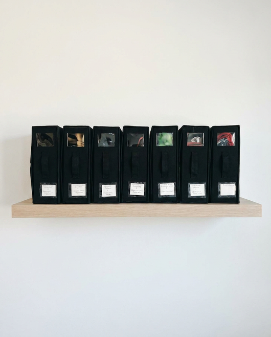 Four True Backdrops backdrop storage organizers with adjustable straps and compartments for easy organization of photography backdrops.