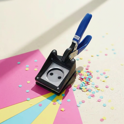 Handling cutter for 35mm keychains by True Backdrops, showing a precision tool with a handle and cutting blade in a close-up shot.