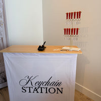 Recycling station keychain attached to a fabric pop-up counter by RecycleDisplay, showcasing portable event display setup.