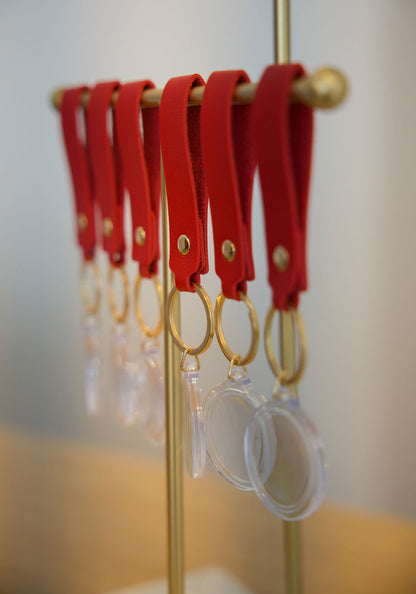 Assorted pre-assembled keychains and station from True Backdrops Keychain Station Starter Pack, displayed on a table.