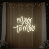 Light Your Way Miss to Mrs neon wedding sign glowing with bright pink and white LED lights on a dark background.