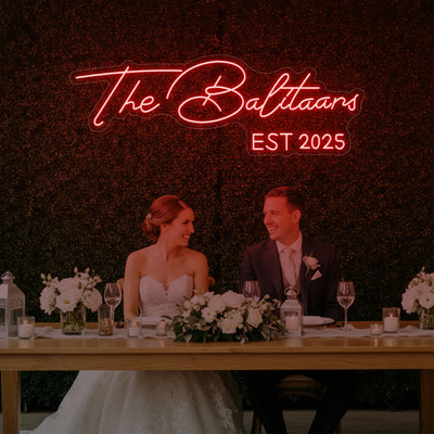 Custom wedding neon sign by Light Your Way displaying last names in bright, colorful neon lights for wedding decor.