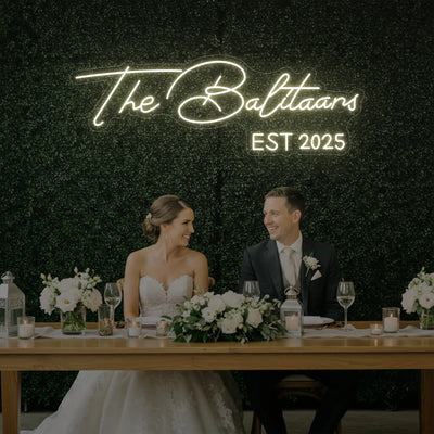 Custom wedding neon sign with last names, illuminated in vibrant colors, designed for wedding decor by Light Your Way.