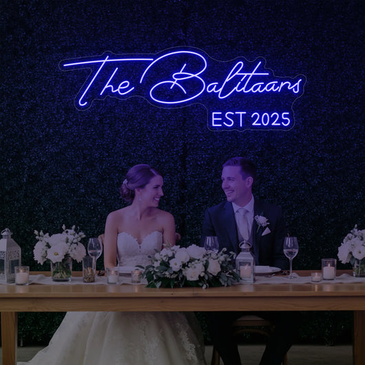 Custom wedding neon sign with last names, illuminated in bright colors, designed for wedding décor by Light Your Way.