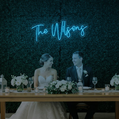 Custom wedding last names neon sign by Light Your Way, featuring illuminated personalized wedding décor on a black background.
